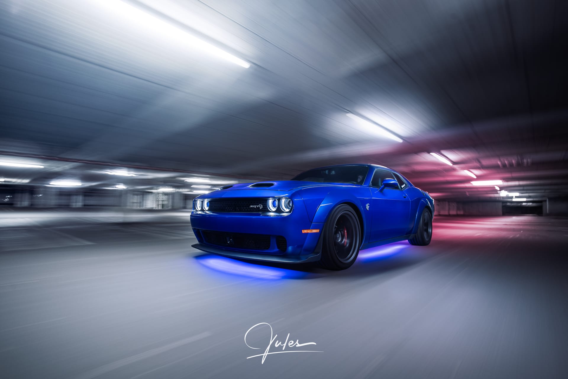Blue Dodge Challenger Hellcat Widebody with blue underglow in a parking garage